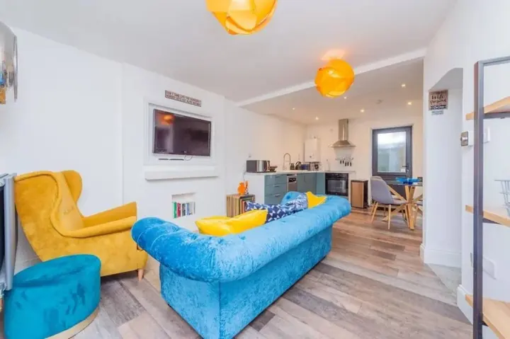 Open-plan lounge with velvet sofa and armchair